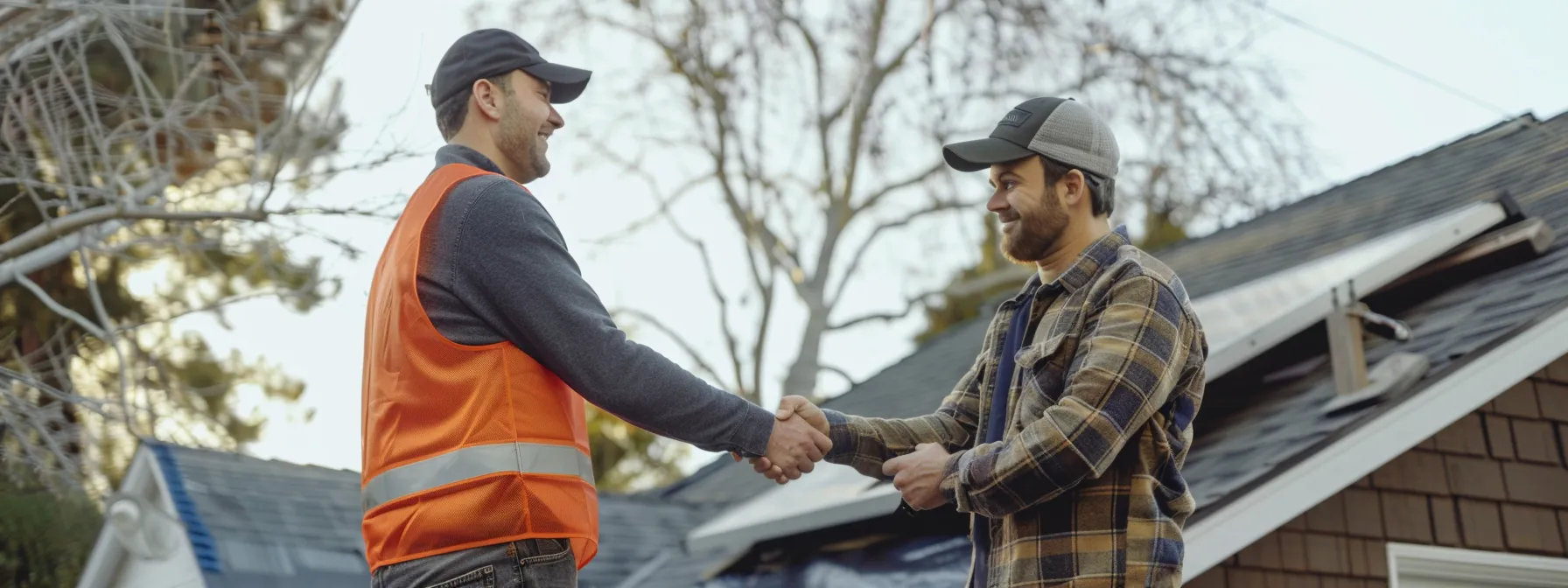 property owner shaking hands with a roofer while reviewing contract terms.